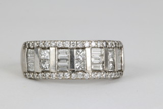 An 18ct white gold brilliant baguette and princess cut diamond ring, approx 1ct size L