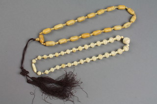 A set of carved Chinese bone beads, a similar string
