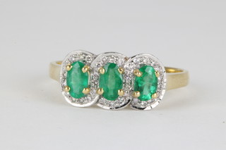 A 14ct yellow gold emerald and diamond triple cluster ring, size O 1/2"