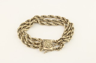 A 9ct gold 3 strand rope twist bracelet with floral clasp, 50 grams