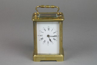 A French 8 day carriage clock with enamelled dial and Roman numerals contained in a gilt case
