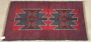 A red ground Afghan rug with 2 stylised octagons to the centre within multi-row borders 54" x 32 1/2" 
