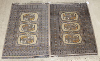 A pair of light tan ground Bokhara rugs with 3 octagons to the centre 53" x 32" 