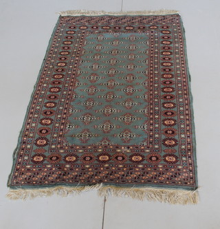 A green ground contemporary Bokhara carpet with stylised octagons to the centre, some wear 58" x 47"