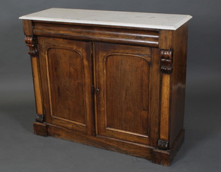 A Regency rosewood chiffonier with white veined marble top fitted a secret drawer above a pair of cupboards enclosed by an arch panelled door, with scrolls to the side and raised on a platform base 35 1/2"h x 42 1/2"w x 15"d 