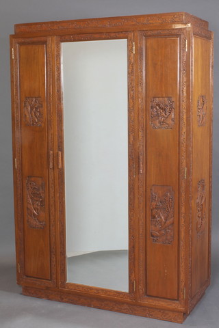 A Chinese 1930's carved camphor wardrobe fitted a cupboard enclosed by a bevelled plate mirrored door flanked by a pair of cupboards with fitted interior 72"h x 48"w x 21"d