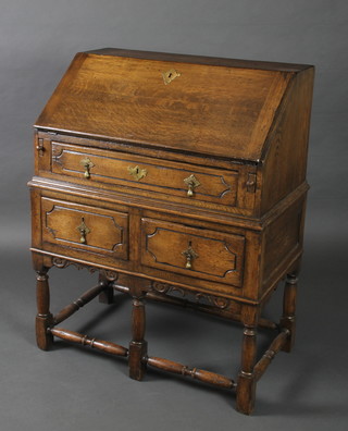 A 17th/18th Century style oak bureau, the fall front enclosing a well fitted interior above 1 long and 2 short drawers, raised on turned and block supports 38 1/2"h x 30"w x 18"d 