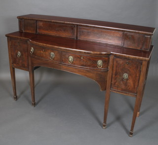 A Georgian mahogany bow front sideboard with raised superstructure to the back, fitted 3 cupboards and 2 drawers flanked by a pair of cupboards, raised on 6 square tapering supports ending in spade feet 44"h x 66"w x 19"d 