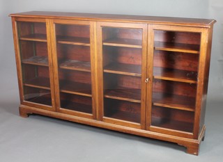 An Edwardian walnut double bookcase fitted adjustable shelves enclosed by glazed panelled doors, raised on bracket feet 42"h x 72"w x 14"d