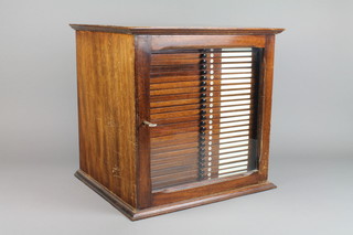 A mahogany 28 drawer tabletop microscope slide chest enclosed by a panelled door, raised on a moulded base, 15"h x 16"w x 13"d 