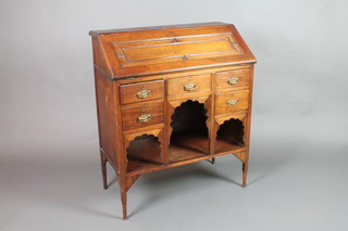 An Edwardian mahogany bureau, the fall front revealing a well fitted interior above 1 long and 4 short drawers with arch shaped niches, raised on square tapering supports 36"h x 31"w x 16"d
