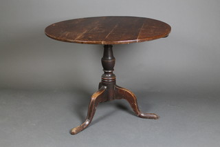 A 19th Century circular oak snap top tea table, raised on a turned column and tripod base 26"h x 34 1/2" diam.
