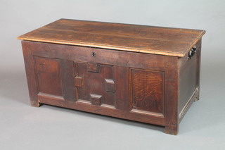 An 18th Century oak coffer of panelled construction with hinged lid, the interior fitted a candle box, having later iron drop handles to the sides 22"h x 49"w 