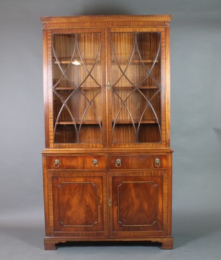 A Georgian style mahogany bookcase on cabinet, the upper section with moulded and dentil cornice, fitted shelves enclosed by astragal glazed panelled doors, the base fitted 2 long drawers above panelled doors, raised on bracket feet 81"h x 45"w x 16"d 