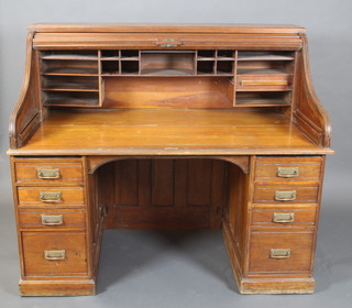 An American walnut roll top desk, the interior fitted pigeon holes, the pedestals fitted 4 drawers with brass swan neck drop handles 50"h x 60"w x 35"d 
