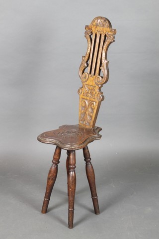 A Victorian carved oak spinning chair with lyre shaped back, raised on turned supports 