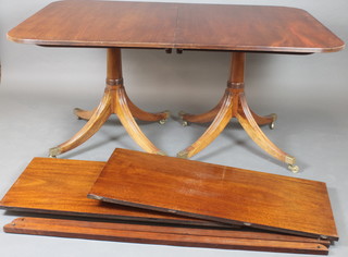 A Georgian style mahogany D end twin pillar dining table with 2 extra leaves, raised on quadripartite supports with brass caps and casters 29"h x 60"l x 98"l with extra leaves x 42"w  