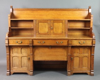 A Victorian Arts & Crafts Pugin style oak sideboard, the raised back fitted 3 shelves and having cupboard to centre above 1 long and 2 short drawers above a cupboard with fall front flanked by a pair of cupboards with panelled doors 58"h x 72"w x 24"d