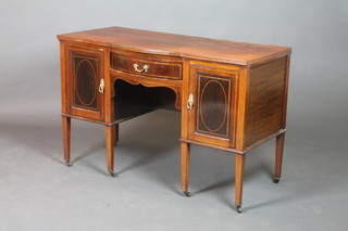 An Edwardian inlaid mahogany bow front dressing table fitted a drawer flanked by a pair of cupboards, raised on square tapering supports ending in brass caps and casters 29 1/2"h x 47"w x 22 1/2"d 