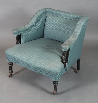 A Victorian ebonised armchair upholstered in blue material, raised on turned supports