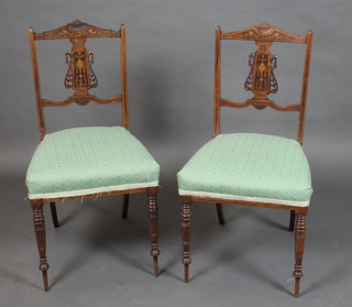 A pair of Victorian inlaid rosewood slat back bedroom chairs, the seats upholstered in green material, raised on turned supports 