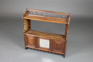 An Edwardian walnut hanging cabinet incorporating a shelf above a cupboard enclosed by a bevelled plate panelled mirror flanked by a pair of cupboards with bobbin turned decoration 24"h x 24"w x 6"d 