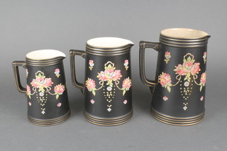 A set of 3 Crown Devon graduated black ground jugs decorated with flowers