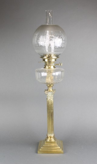 A Victorian glass oil lamp reservoir raised on a reeded brass column with Corinthian capital, etched glass shade and clear glass chimney 30"h together with an additional clear glass chimney 