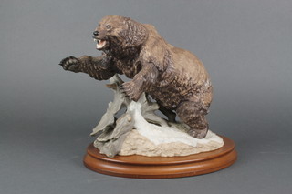 A porcelain figure of a grizzly bear on a wooden base 12"  (one claw is chipped)