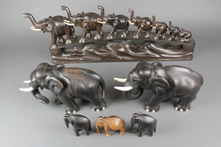 A bridge of 7 carved ebony elephants with ivory tusks 26" together with 9 other figures of elephants 