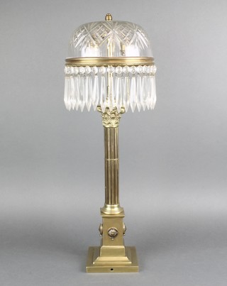 A brass and cut glass table lamp with fluted column and Corinthian capital raised on a stepped base with cut glass shade 