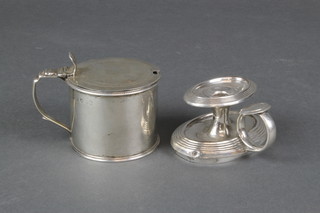 A George III silver circular mustard pot with blue glass liner and S scroll handle, a candle holder