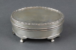 An oval silver coloured trinket box with repousse decoration 4" 