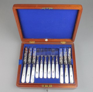 A set of 12 Edwardian engraved silver plate dessert eaters with floral decoration and mother of pearl handles, contained in a walnut canteen