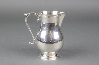 A modern silver baluster cream jug with plain spout and S scroll handle, London 1988, 266 grams