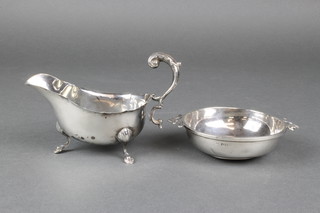 An early 20th Century silver plain bodied quaich with scroll handles, a ditto sauce boat, gross 120 grams