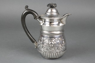 A mid Victorian silver jug with repousse decoration, Reynolds angels, having ebony mounts, London 1889, 354 grams gross