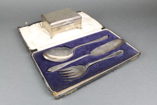 A silver engine turned cigarette box on scroll feet, Birmingham 1919 5" and a cased silver plated serving set 