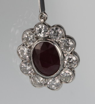 An oval cut ruby and diamond pendant, the centre stone approx 1.5ct, surrounded by 10 brilliant cut diamonds suspended by a single brilliant cut diamond, approx 1.05ct, on an 18ct white gold chain 