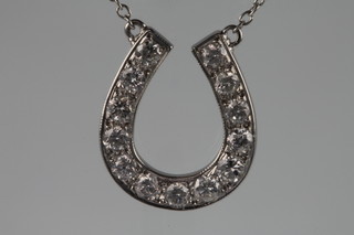 A 13 stone diamond horseshoe pendant on an 18ct white gold chain, approx. 0.55ct 