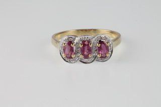 A 14ct yellow gold ruby and diamond triple cluster ring, the rubies approx. 0.99ct, surrounded by brilliant cut diamonds, size N