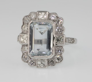 An 18ct white gold aquamarine and diamond cluster ring, the centre cut stone approx. 4ct surrounded by 12 brilliant and 4 princess cut diamonds with 3 diamonds to each shoulder, size O 