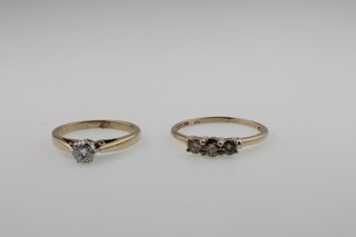 A single stone 9ct gold ring and a champagne coloured 3 stone diamond ring in a 9ct gold mount, size Q and L