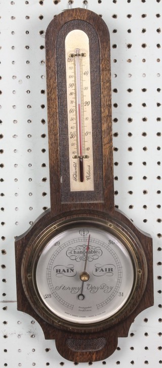 A Short & Mason Art Deco aneroid barometer and thermometer with silvered dial contained in an oak arched wheel case 