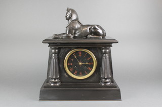 A French 8 day striking mantel clock in the Egyptian taste with Roman numerals, contained in a black marble case with columns to the side and surmounted by a figure of a sphynx 