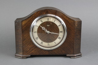 A Smiths Art Deco electric clock with Roman numerals, contained in an oak arched case  
