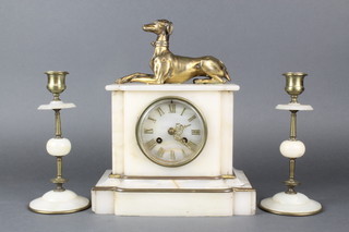 A French 19th Century 3 piece clock garniture, the 8 day striking mantel clock with Roman numerals contained in a white marble case surmounted by a figure of a seated gilt metal greyhound, together with a pair of gilt metal and white marble candlesticks 