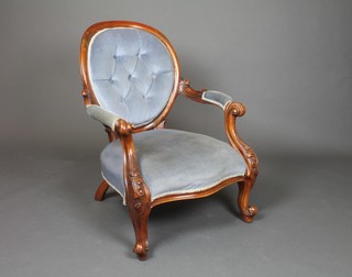 A Victorian carved mahogany show frame open arm chair, the seat of serpentine outline, raised on cabriole supports upholstered in blue buttoned dralon 