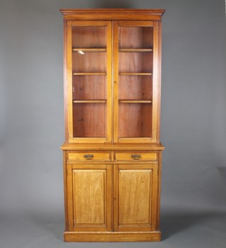 An Edwardian Art Nouveau walnut bookcase on cabinet with moulded cornice, the base fitted 2 long drawers above a double cupboard, raised on a platform base 84"h x 36"w x 17"d 