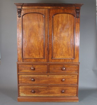 A Victorian mahogany linen press with moulded cornice enclosed by arched panelled doors, the base fitted 2 short and 2 long drawers 80"h x 54"w x 24"d 